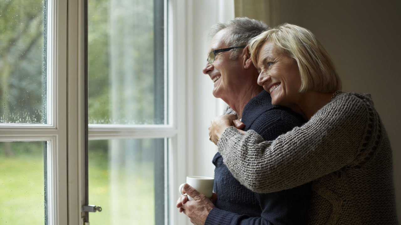 Elder woman hugging her husband