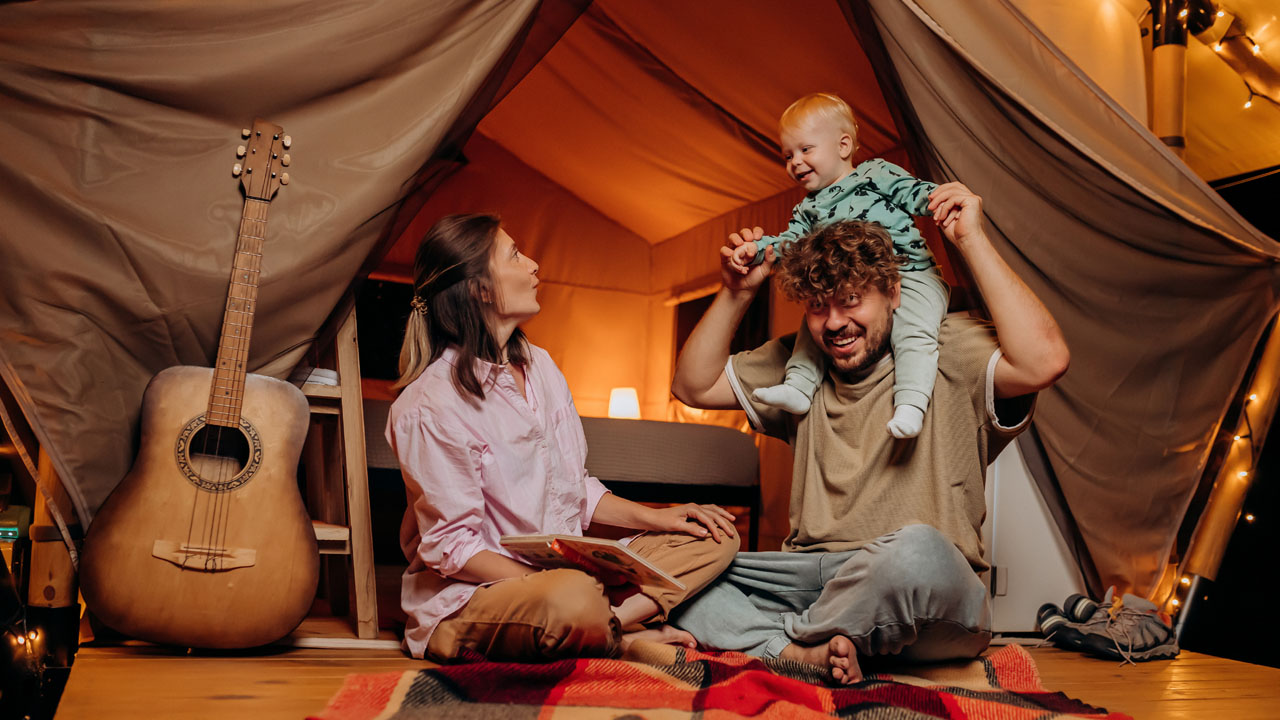 Father is carrying his son on his shoulder while they are playing