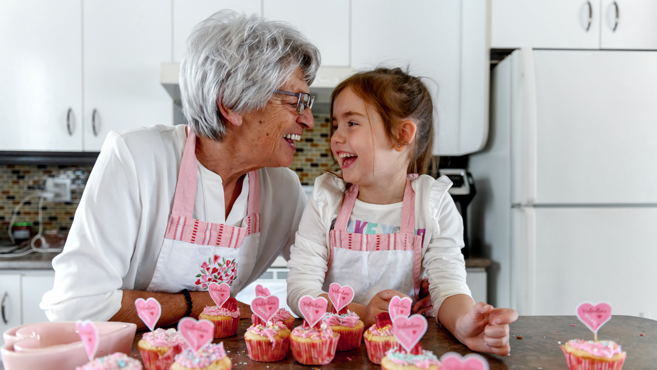 Grandmother and her granddaughter baking cupcakes