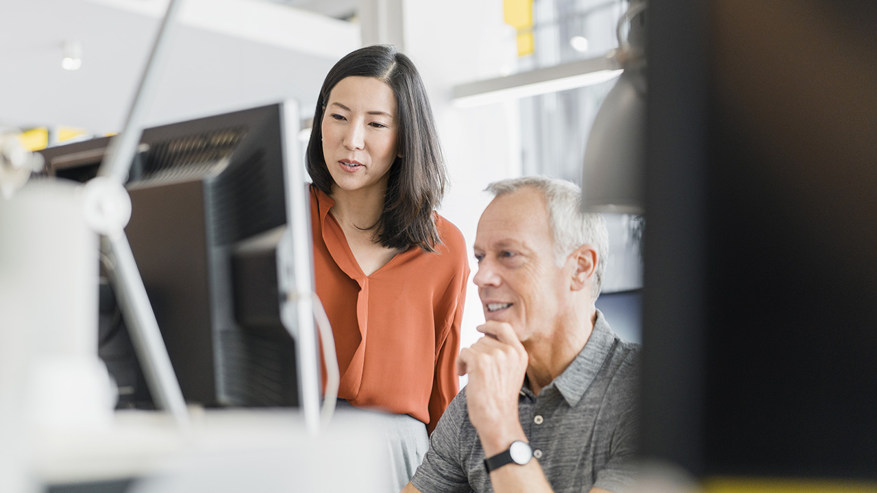 Old man and woman looking to the computer monitor
