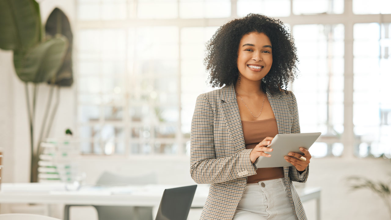 Woman smiling while holding her tablet device