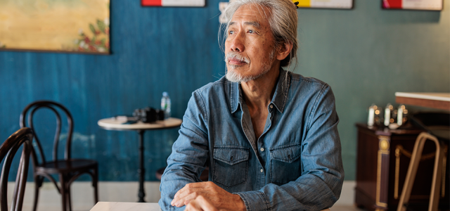 Person sitting at a table pondering their thoughts